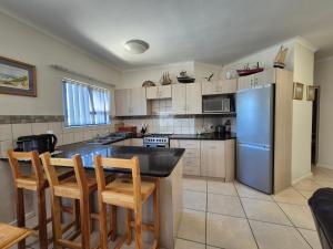 a kitchen with a table and chairs and a refrigerator at Sea side cottage in Stilbaai