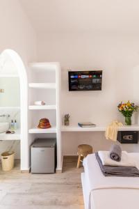 a living room with a couch and a tv on the wall at Alexandra Suites - MYKONOS PORT in Mikonos