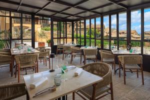 a restaurant with tables and chairs and windows at Palazzo Saloni in Montalcino +72 photos