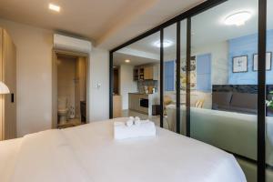 a bedroom with a large white bed and a bathroom at Luxury Designer Studio Sealy Bed Coffee Bar Walk to Cicada Market & Beach in Hua Hin