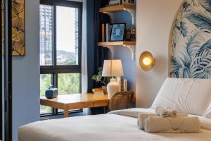 a bedroom with a bed and a desk and a window at Luxury Designer Studio Sealy Bed Coffee Bar Walk to Cicada Market & Beach in Hua Hin