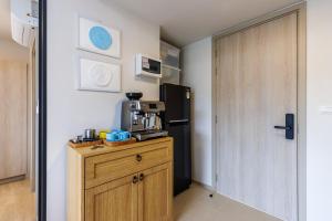 a kitchen with a black refrigerator and a wooden cabinet at Luxury Designer Studio Sealy Bed Coffee Bar Walk to Cicada Market & Beach in Hua Hin +45 photos