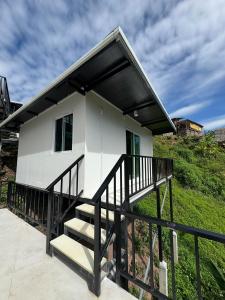a small white house with a black railing at เหนือสะปัน in Ban Huai Ti