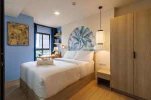 a bedroom with a large bed with a blue wall at Luxury Designer Studio Sealy Bed Coffee Bar Walk to Cicada Market & Beach in Hua Hin