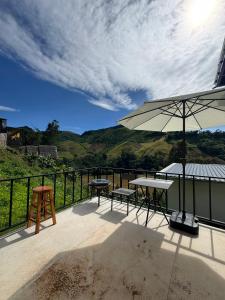 a patio with two tables and an umbrella at เหนือสะปัน in Ban Huai Ti