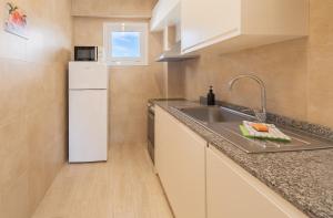 a small kitchen with a sink and a refrigerator at DOLS MAR APARTMENTS in Camp de Mar