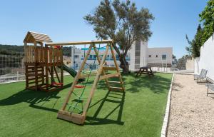 two wooden play equipment on a green lawn at DOLS MAR APARTMENTS in Camp de Mar