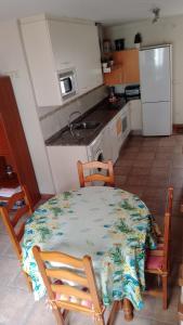 a kitchen with a table and two chairs and a table and a kitchen at Encanto Rural in Arnedillo