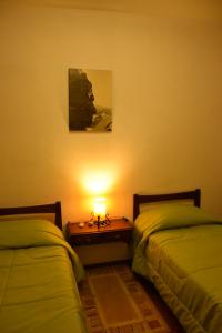 a room with two beds and a table with a lamp at SUIZO Hotel in Colonia Suiza