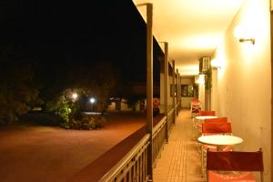 a balcony with tables and chairs at night at SUIZO Hotel in Colonia Suiza