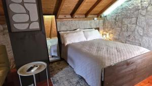 a bedroom with a bed and a stone wall at Moose House EV Charging Pool Gated Community in Loivos +38 photos
