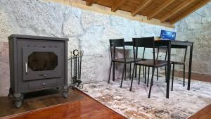 a stove and some chairs and a table and a table and a fireplace at Moose House EV Charging Pool Gated Community in Loivos