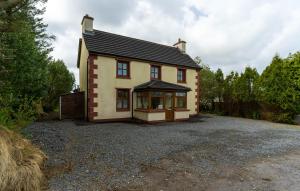 a large house with a driveway in front of it at Stonechat Cottage - Portmagee in Portmagee