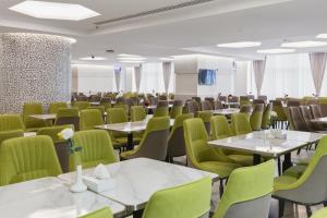 a conference room with tables and green chairs at Taj Park Hotel in Mecca