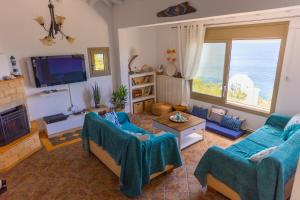 a living room with two couches and a tv at Captain's Villa in Skiathos