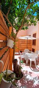 a patio with a table and chairs and a tree at Casa Margherita in Casa Santa