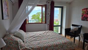 a bedroom with a bed and a window and a chair at Boutique Home Saltaragazza in Petrovac na Moru +170 photos