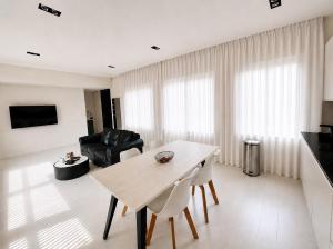 a white living room with a table and chairs at Elegant Central Apartment Quiet and Bright in Brussels