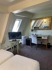 a bedroom with a desk and a computer in a room at Hotel Ajoncs d'Or in Saint Malo