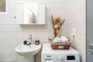 a bathroom with a sink and a washing machine at Anthia studio in Koutsourás