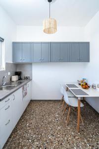 a kitchen with white cabinets and a table and chairs at Anthia studio in Koutsourás