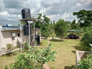 a garden with a water tank on the side of a house at Laker's barn in Gulu