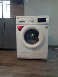 a white washing machine sitting on top of a floor at Laker's barn in Gulu