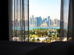 a view of a city skyline from a window at Saraya Corniche Hotel in Doha