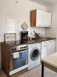 a kitchen with a stove and a washing machine at Apartment Weserblick in Hameln