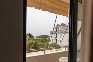 a window with a view of a building at Poseidon Family Hotel Ksamil in Ksamil +46 photos