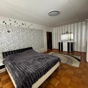 a bedroom with a bed and a wall at Two bedroom in Park Zone in Kamianets-Podilskyi