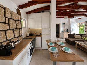 a kitchen and living room with a table and a living room at Villa Sunset, Dobrota in Dobrota