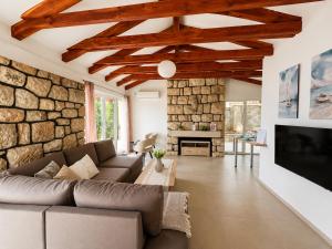 a living room with a couch and a stone wall at Villa Sunset, Dobrota in Dobrota