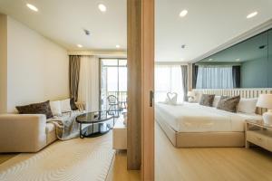 a bedroom with a large bed and a living room at The Ozone Residences Bangtao Official Account in Bang Tao Beach +107 photos