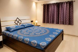 a bedroom with a bed with a blue comforter at Vista Royal 2BHK With Private Pool in Igatpuri