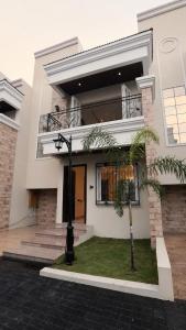 a white house with a palm tree in front of it at Vista Royal 2BHK With Private Pool in Igatpuri