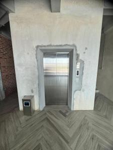 a hallway with a door in a room with wood floors at Brick Box Family Hotel Ipoh in Ipoh