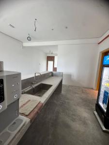a kitchen with a sink and a tv in a room at Brick Box Family Hotel Ipoh in Ipoh