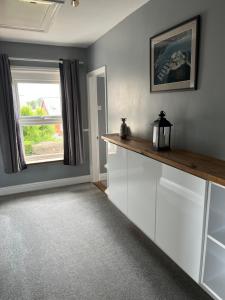 a kitchen with white cabinets and a window at Apartment 288 in Lower Swanwick