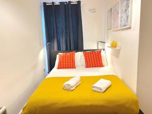a bedroom with a yellow bed with orange pillows at One Bedroom Central Site Apartment in Dublin