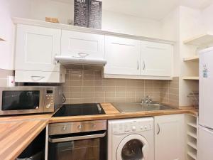 a kitchen with white cabinets and a dishwasher at One Bedroom Central Site Apartment in Dublin
