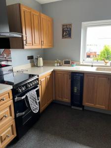a kitchen with wooden cabinets and a black stove top oven at Apartment 288 in Lower Swanwick +36 photos