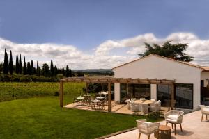 a patio with tables and chairs in a garden at Horizon Carcassonne in Carcassonne