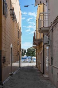 an alley between two buildings with a tree in the distance at Adriatic Breeze Rooms in Mola di Bari