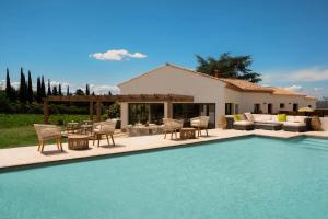a swimming pool with chairs and a table and a house at Horizon Carcassonne in Carcassonne