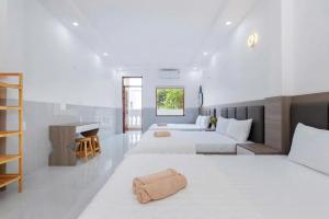 a bedroom with two beds and a desk in it at Sói Homestay B10 HQL in Xã Thang Tam +33 photos