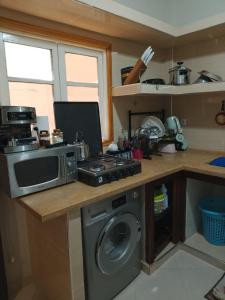 a kitchen with a washing machine and a microwave at Maison d'hôte Najah 1 in Khenifra +16 photos
