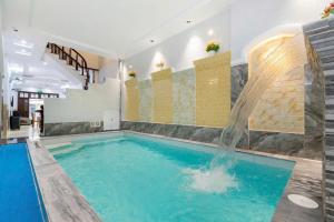 a swimming pool with a waterfall in a building at Sói Homestay B10 HQL in Xã Thang Tam