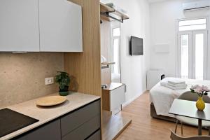 a kitchen and living room with a bed and a table at Adriatic Breeze Rooms in Mola di Bari