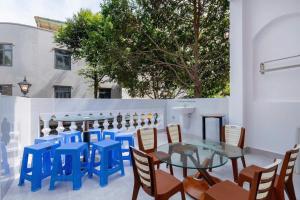 a patio with blue chairs and a glass table at Sói Homestay B10 HQL in Xã Thang Tam